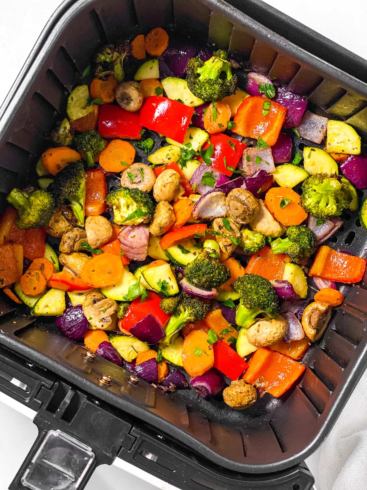 overhead view of roasted vegetables in air fryer basket