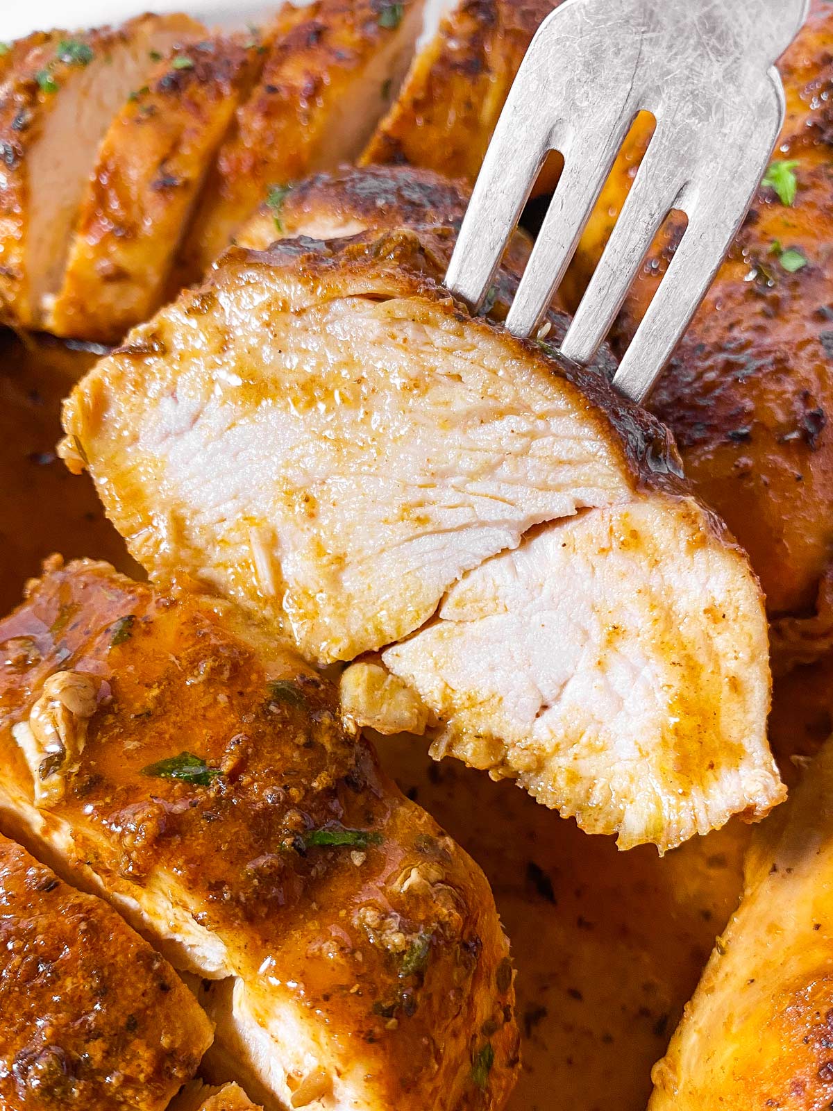 close up photo of sliced chicken breast speared on fork