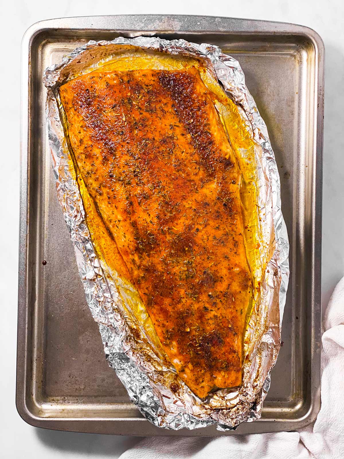 baked salmon fillet on foil lined baking sheet