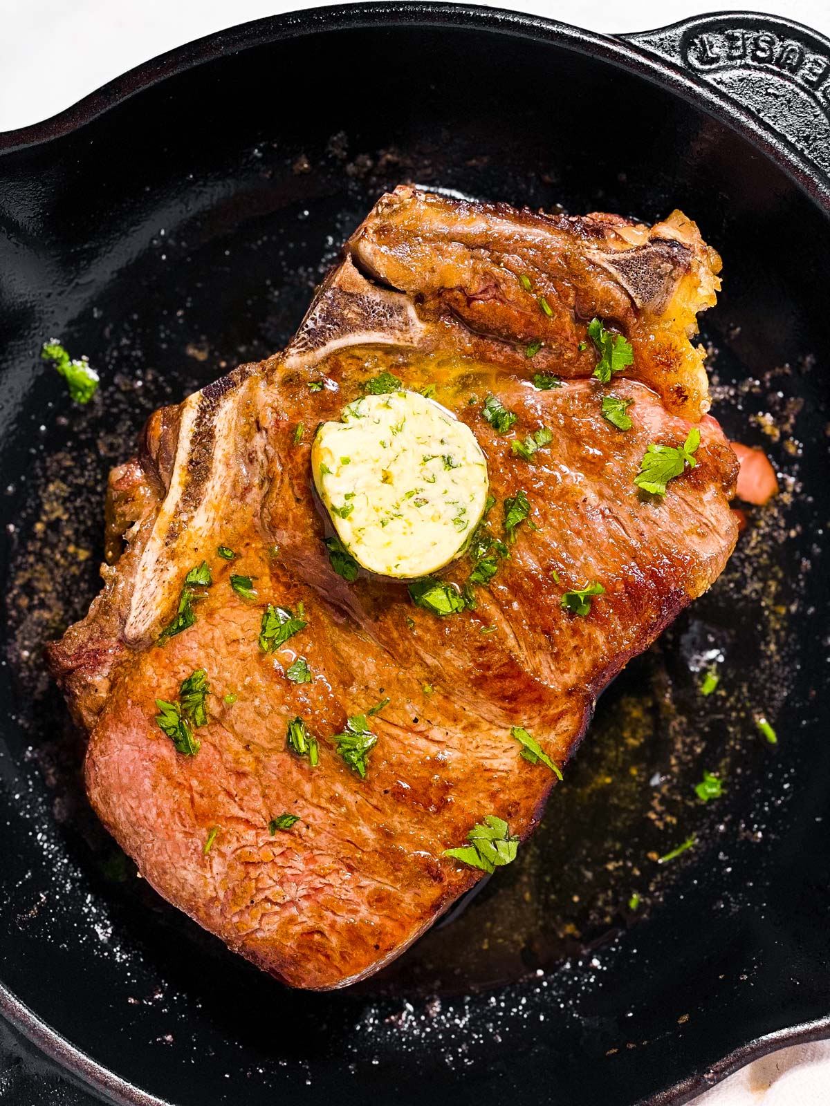 overhead view of oven baked steak in cast iron skillet