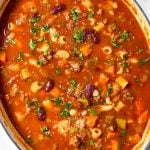 overhead view of oval white pot filled with pasta fagioli soup