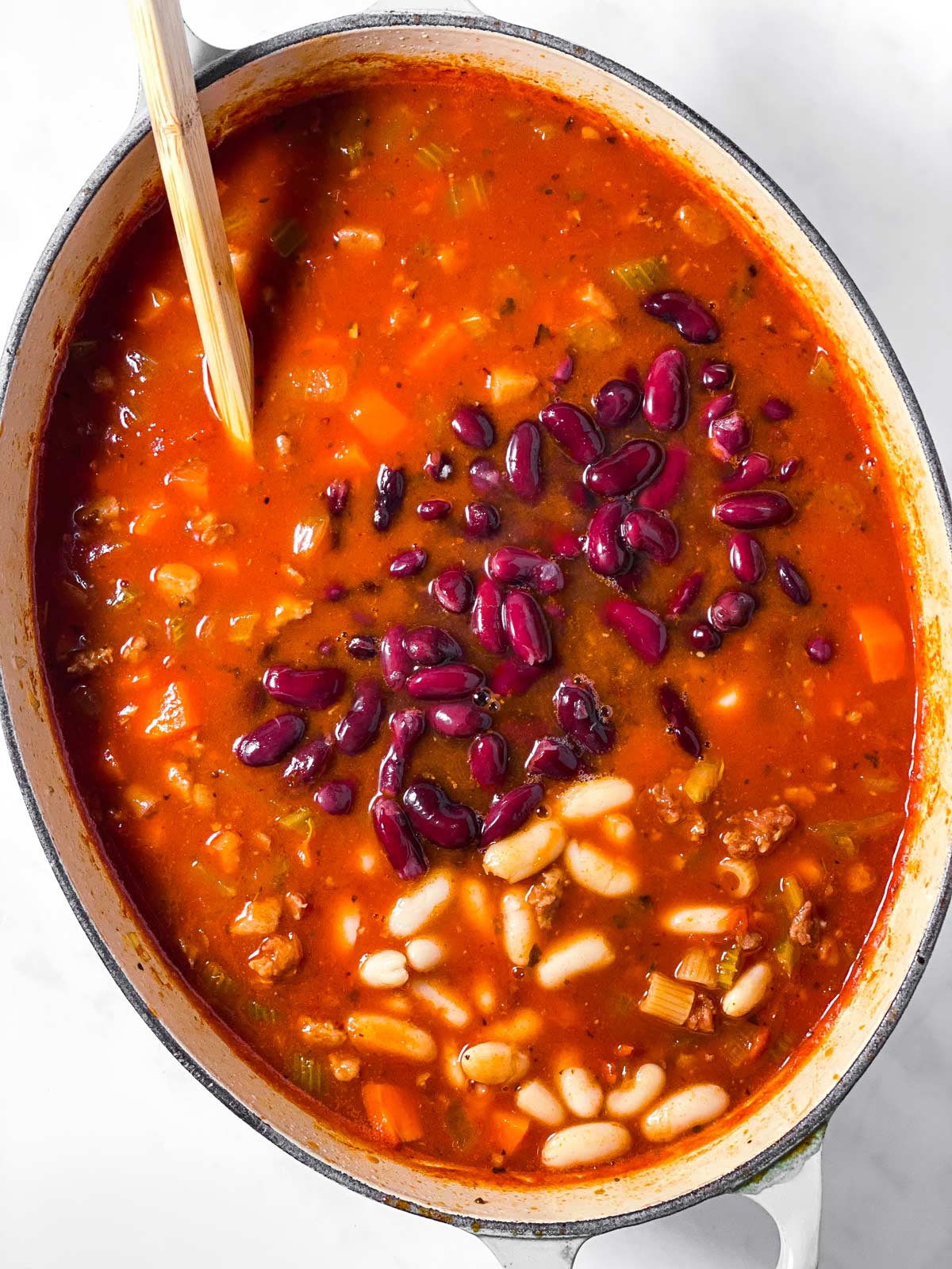 oval Dutch oven filled with soup and beans