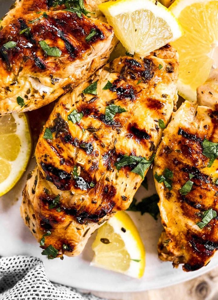 overhead view of three grilled chicken breasts seasoned with Greek marinade