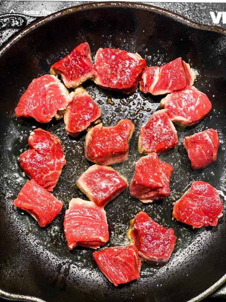 raw steak bites in cast iron skillet