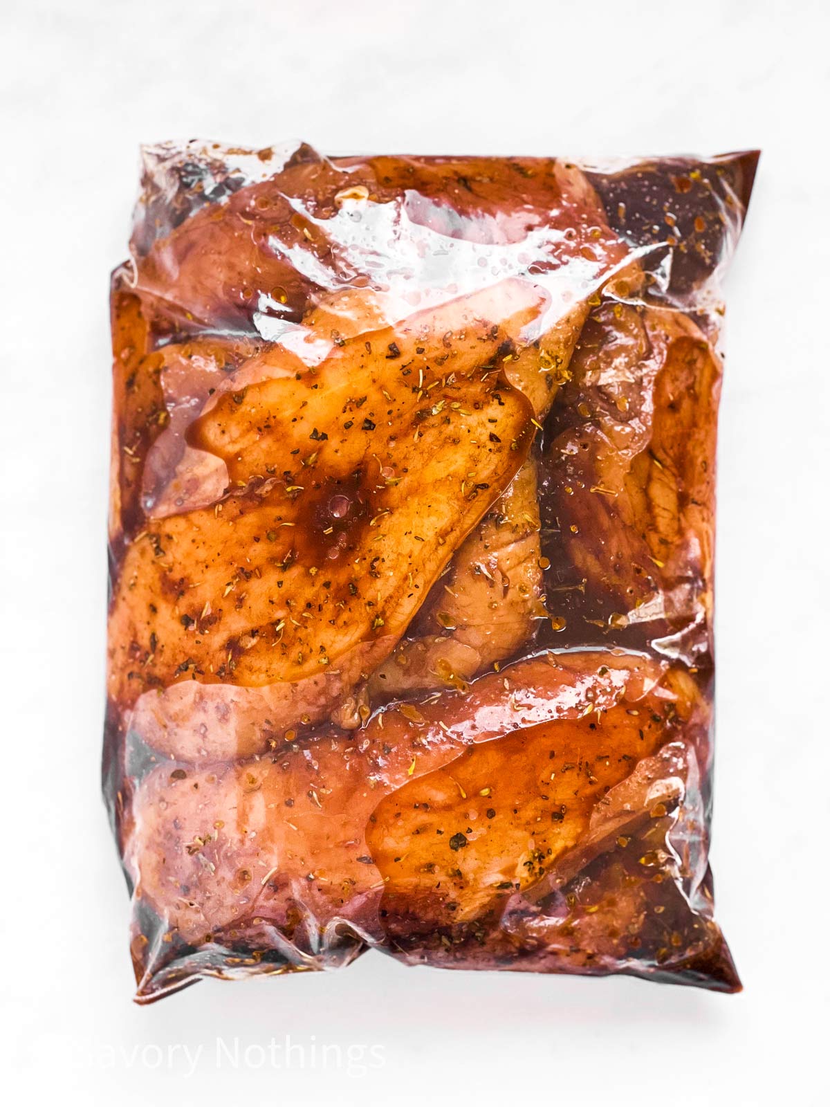 overhead view of raw chicken breast in zip-top bag with balsamic chicken marinade