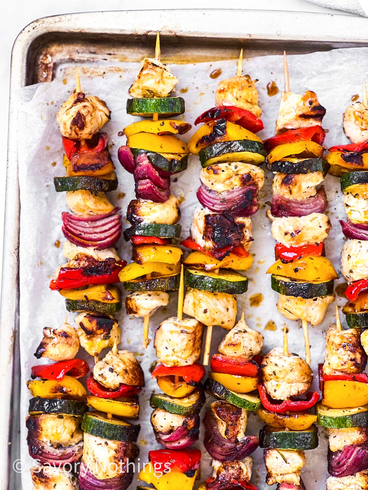 overhead view of grilled chicken kabobs on baking sheet