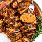 overhead view of marinated, grilled and sliced pork tenderloin on plate with fork