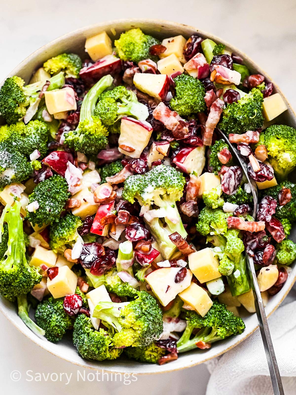 overhead closeup of broccoli salad in white bowl