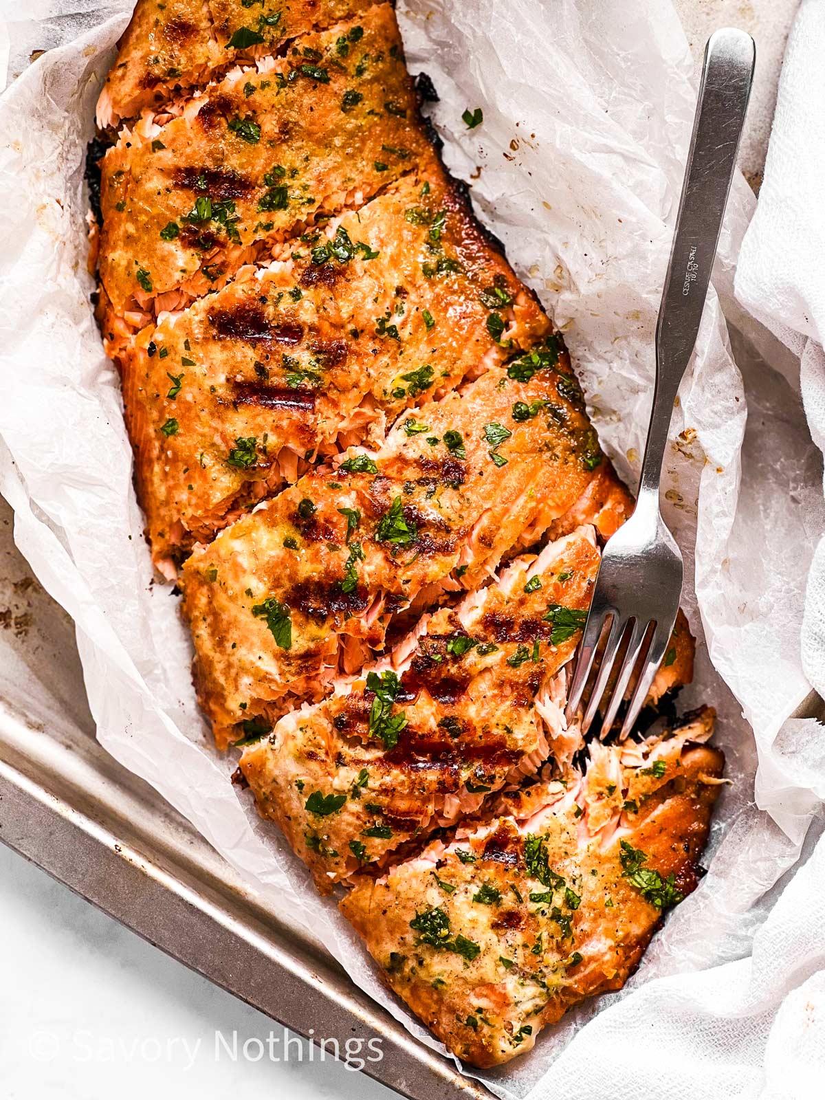 overhead view of marinated and grilled salmon fillet on metal tray