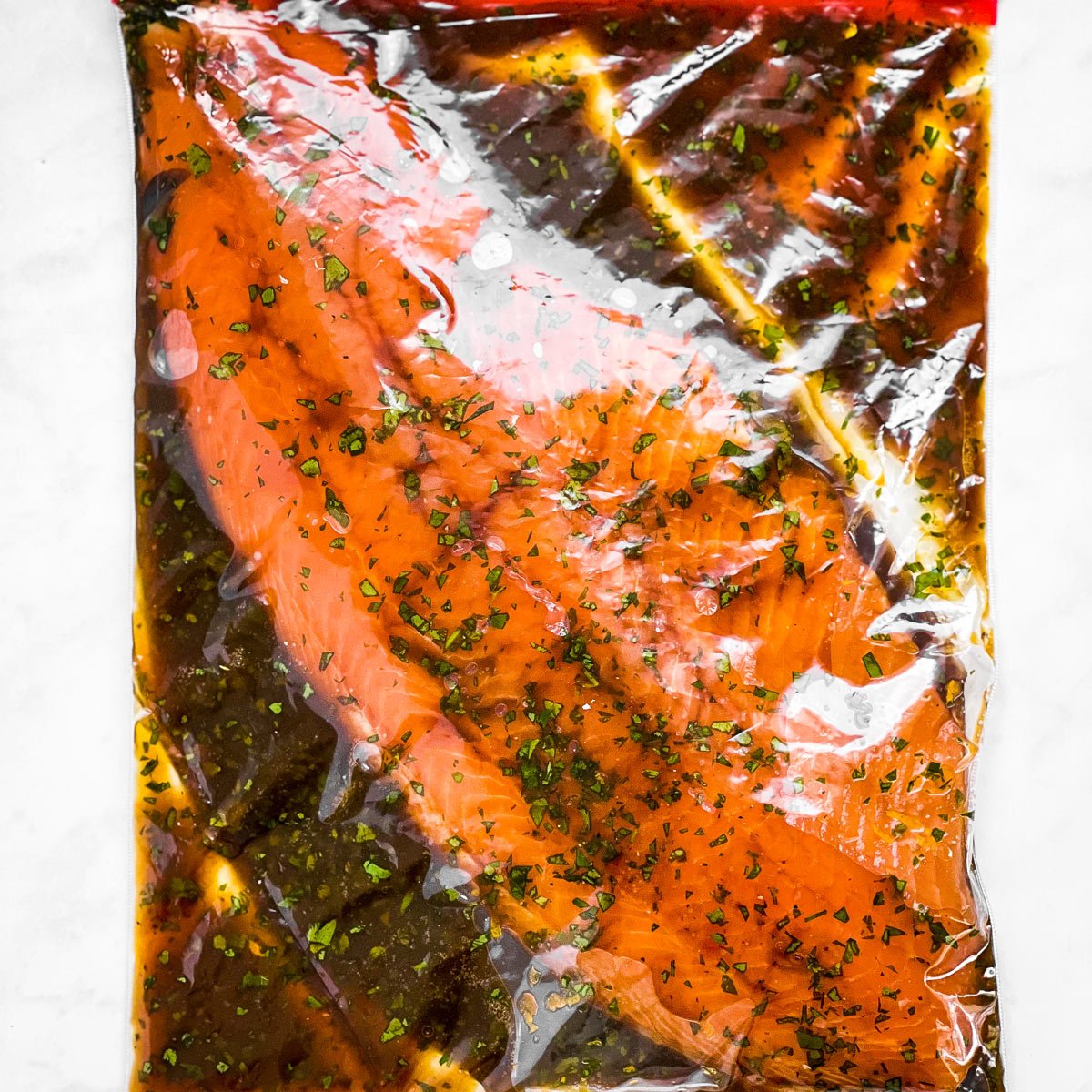 overhead view of salmon with marinade in zip-top bag