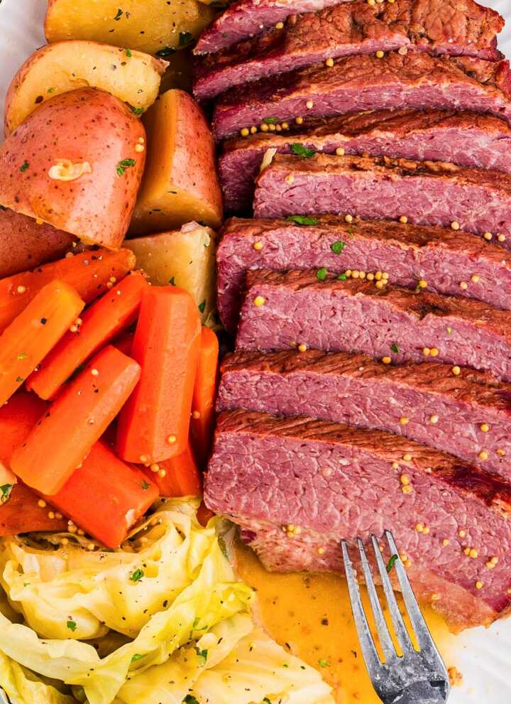 Sliced corned beef with cabbage, carrots, and potatoes on a serving platter