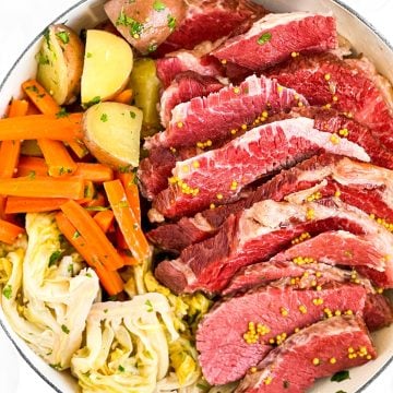 overhead view of sliced corned beef and vegetables in white round pot