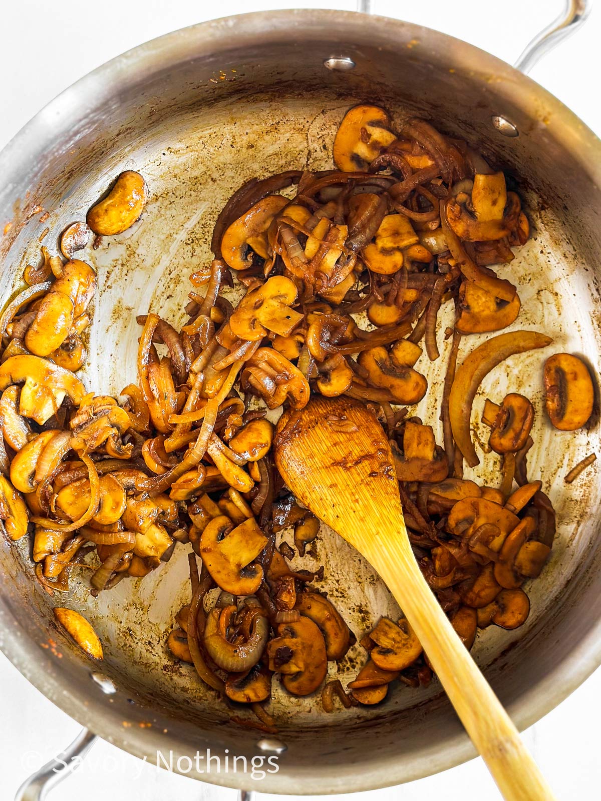 overhead view of sliced and cooked onion and mushrooms in skillet