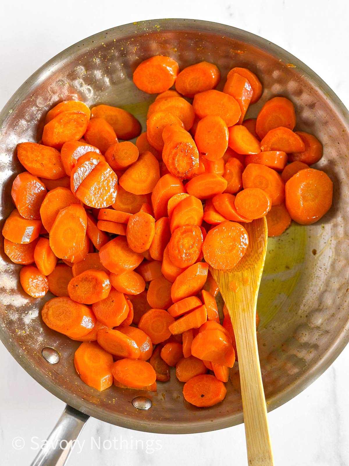 overhead view of cooked sliced carrots in skillet