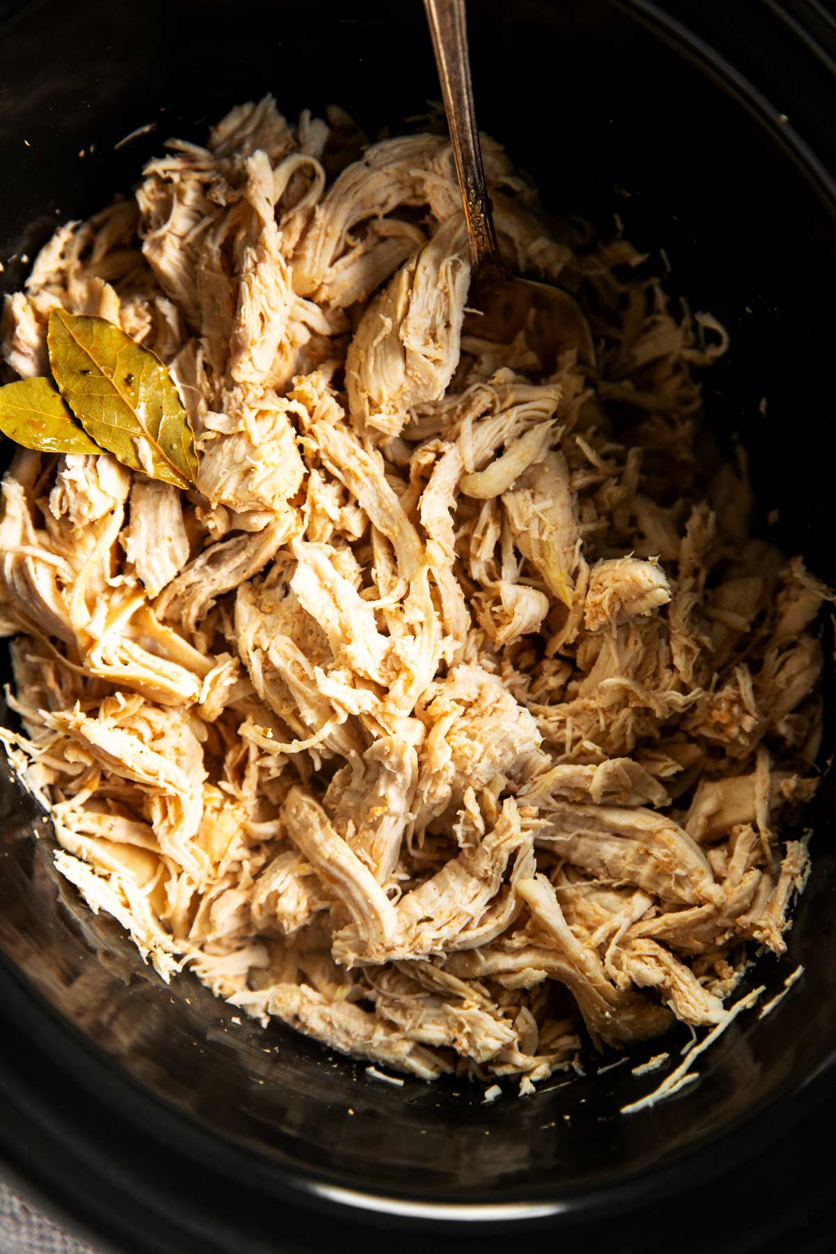 overhead close up view of shredded chicken in slow cooker crock