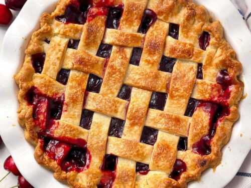 overhead view of cherry pie with lattice crust in white pie dish
