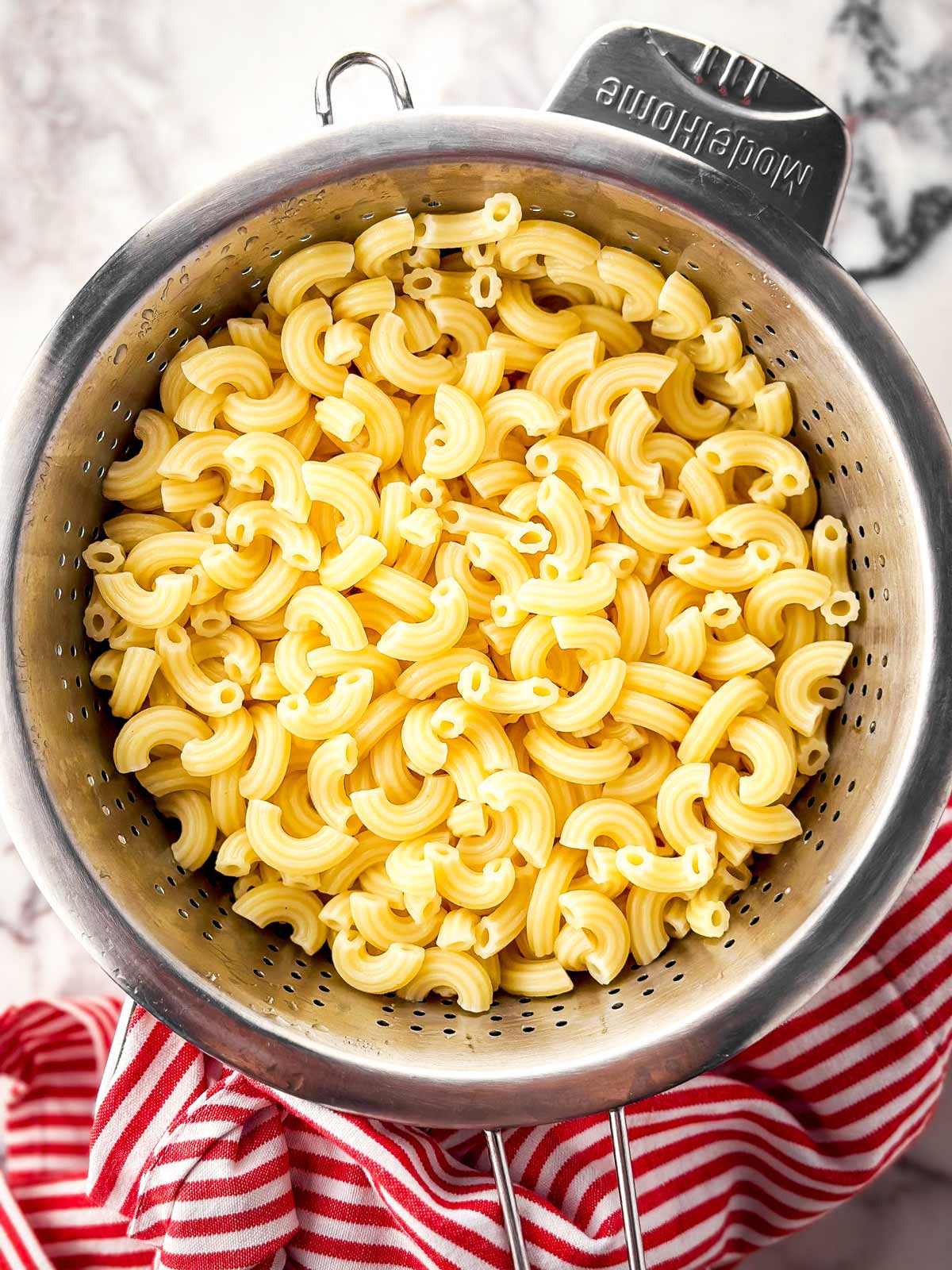 overhead view of boiled macaroni draining in colander