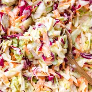 overhead close up view of wooden spoon filled with coleslaw