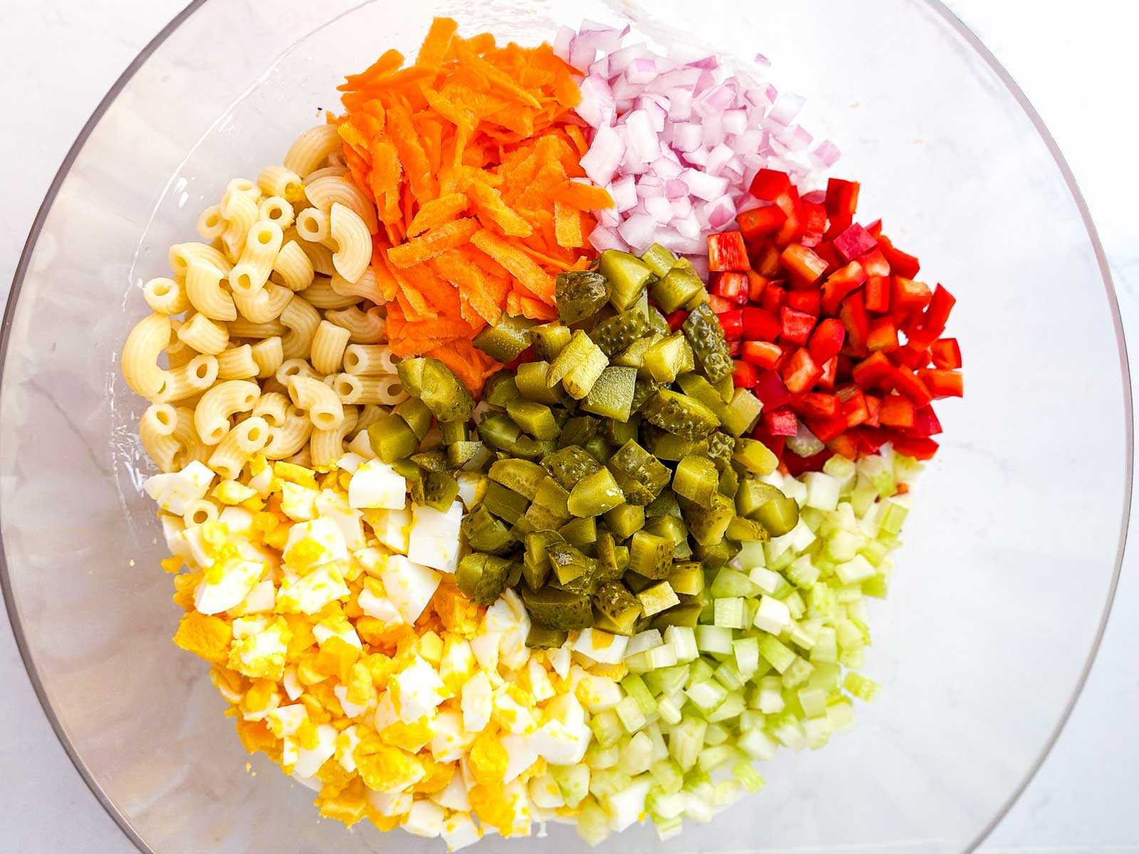 overhead view of macaroni salad ingredients in glass bowl