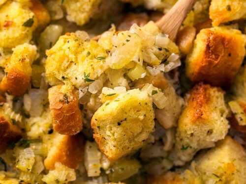 overhead close up photo of wooden spoon scooping stuffing from casserole