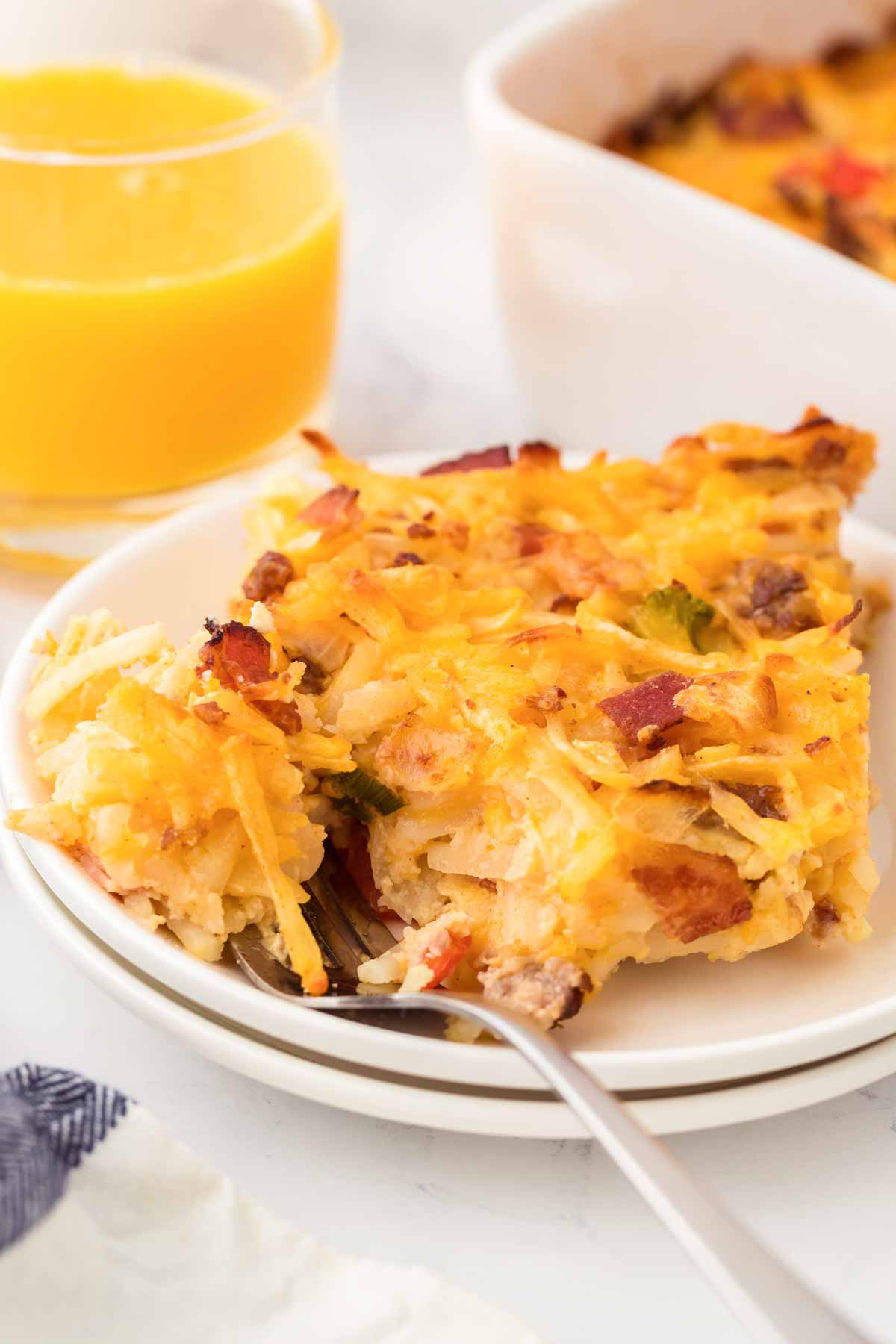 frontal view of hashbrown breakfast casserole on white plate with fork