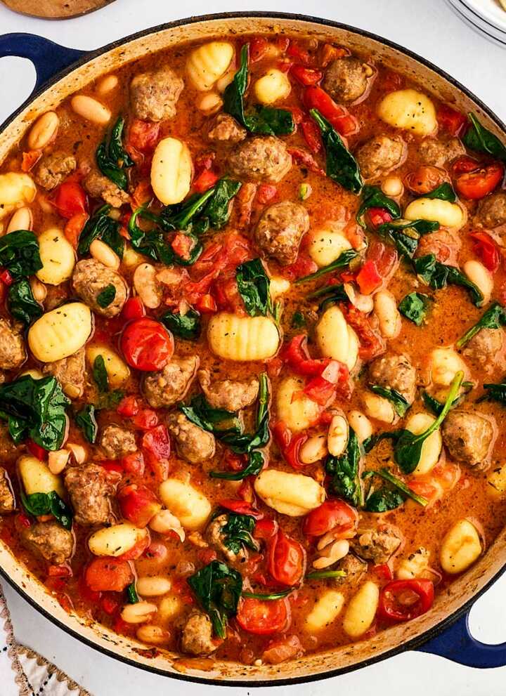 overhead view of tuscan white bean sausage gnocchi in dutch oven