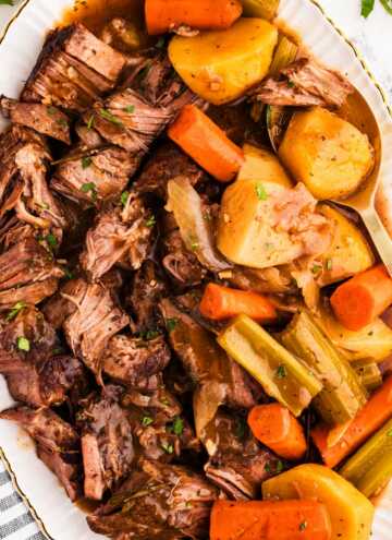 overhead view of pot roast on platter with carrots and potatoes
