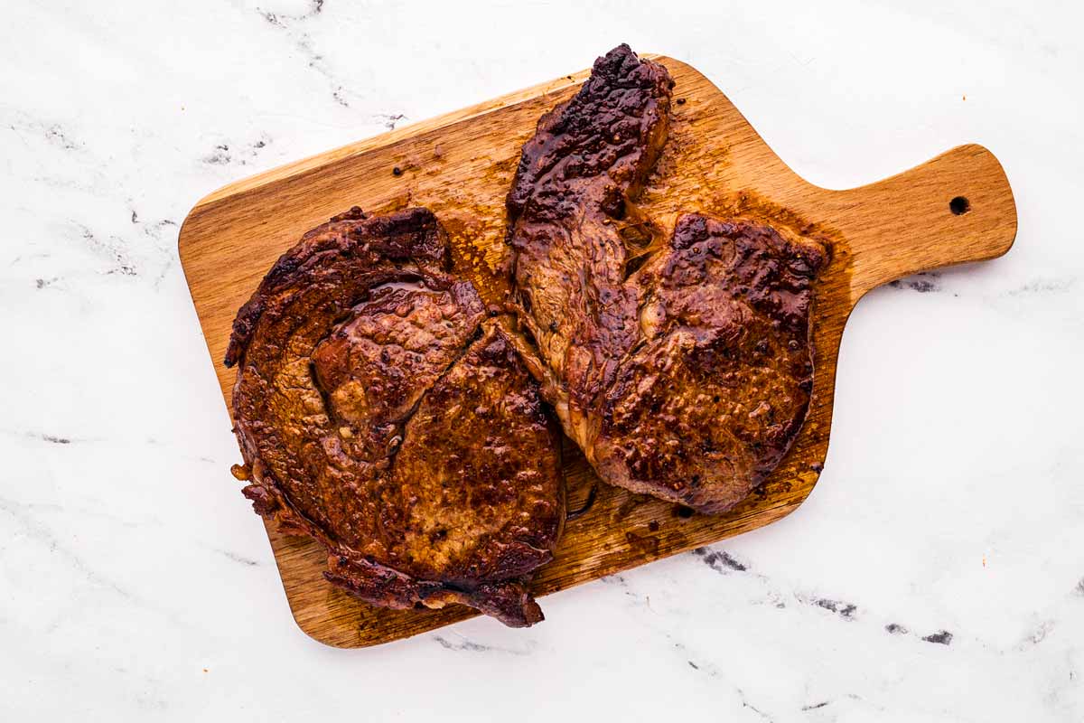 overhead view of steaks resting on cutting board