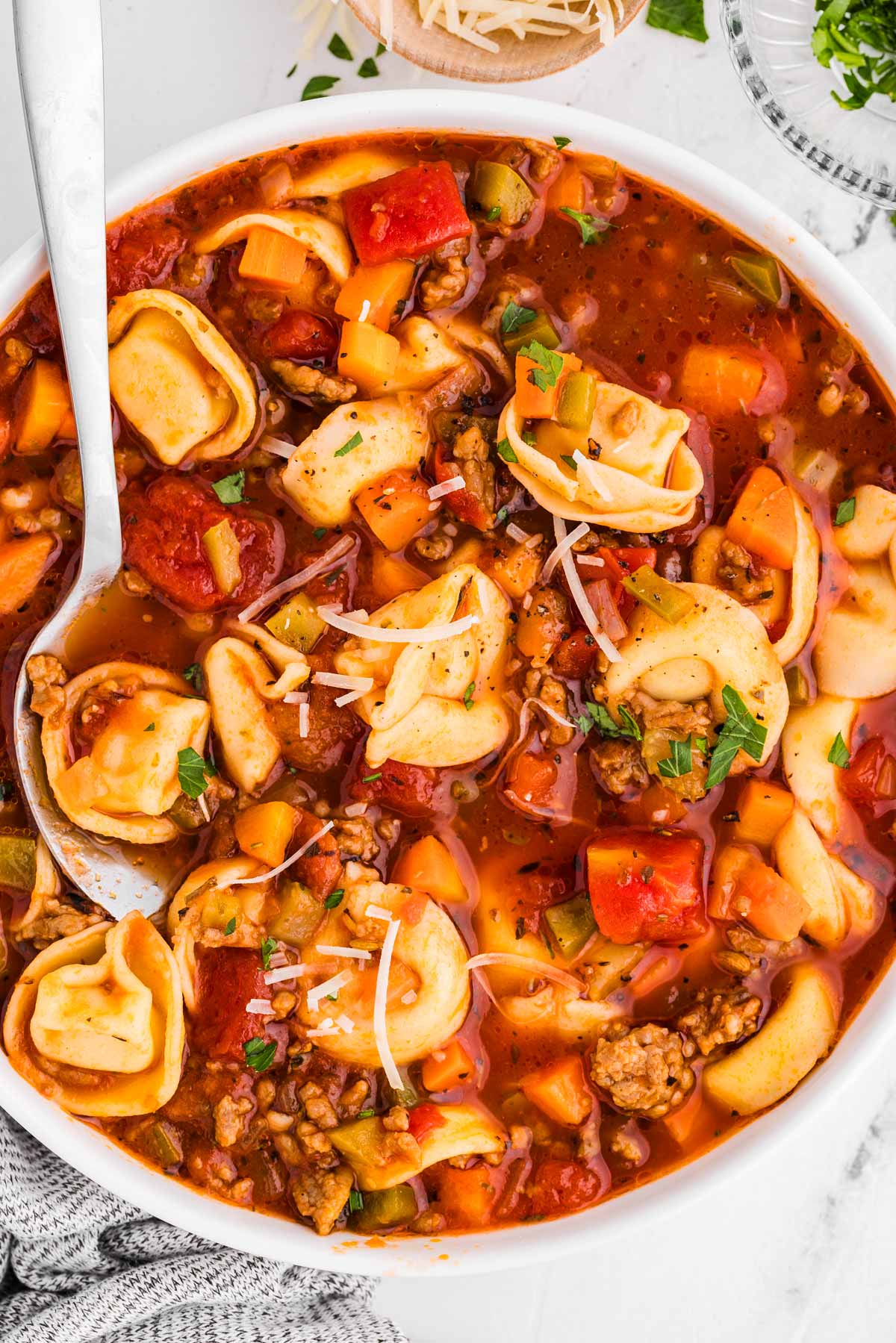 overhead view of sausage tortellini soup in white bowl