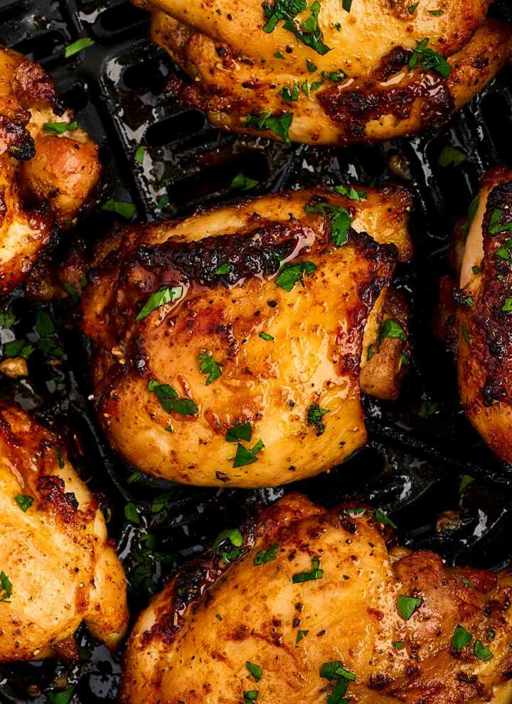 overhead view of air fryer boneless chicken thighs in air fryer basket