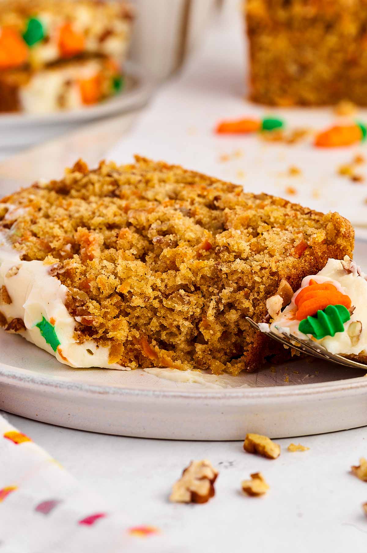 frontal view of carrot cake slice with bite taken out