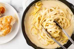 overhead view of creamy lemon pasta next to plate with seared chicken
