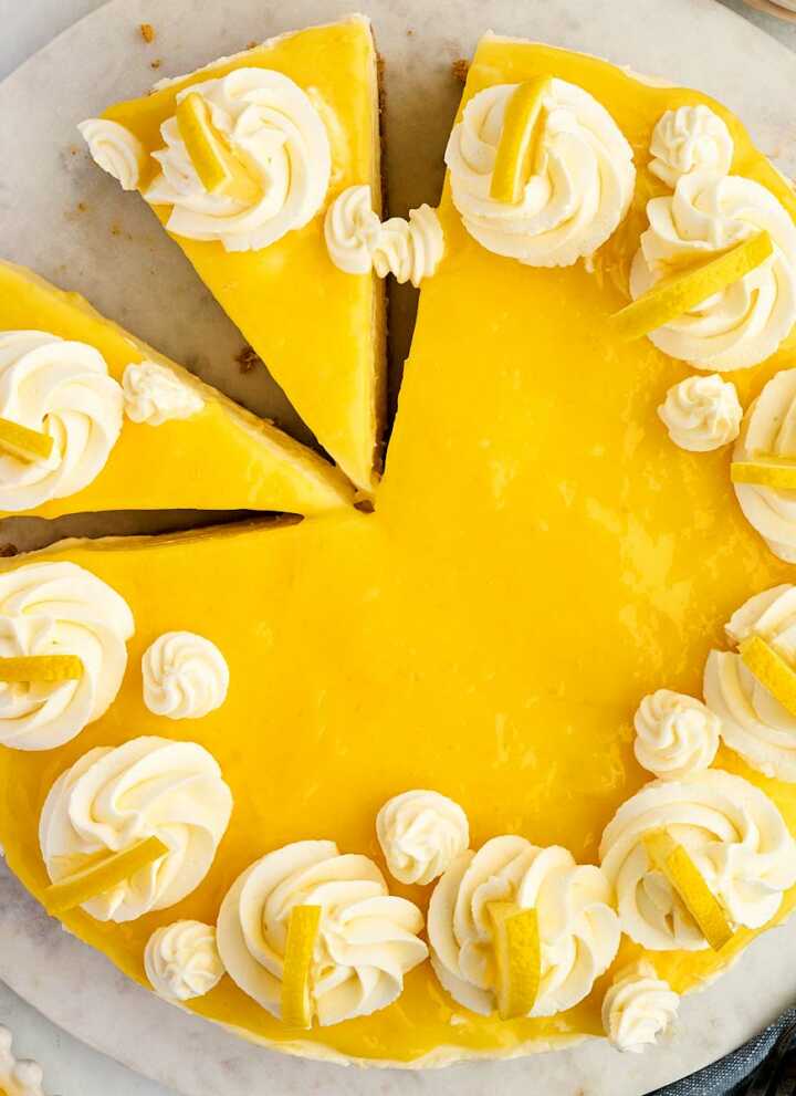 overhead view of sliced lemon cheesecake on marble board