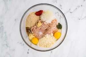 overhead view of ingredients for chicken meatloaf in glass bowl