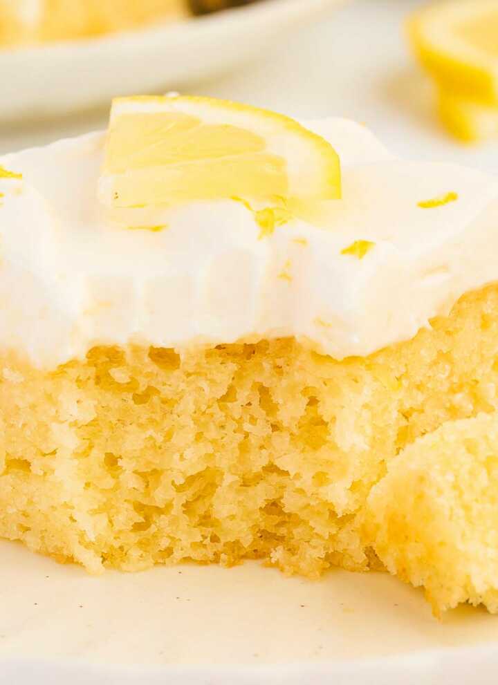 lemon sheet cake on plate with bite taken out