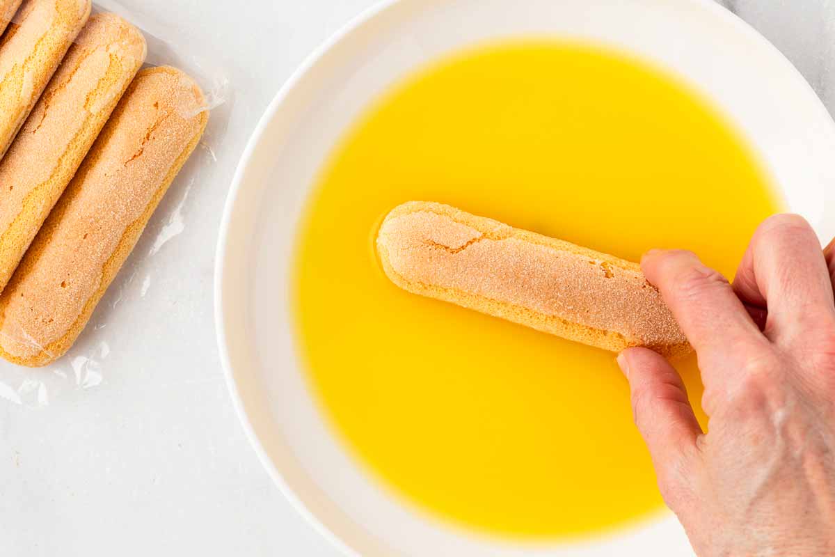 dipping ladyfingers in orange juice