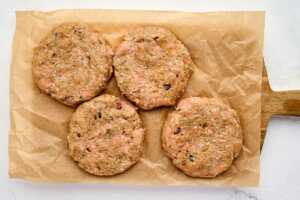 four turkey burger patties on lined cutting board