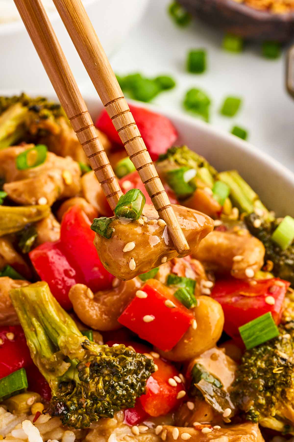 cashew chicken being held with chopsticks