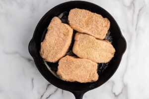 unbaked pork chops on cast iron pan