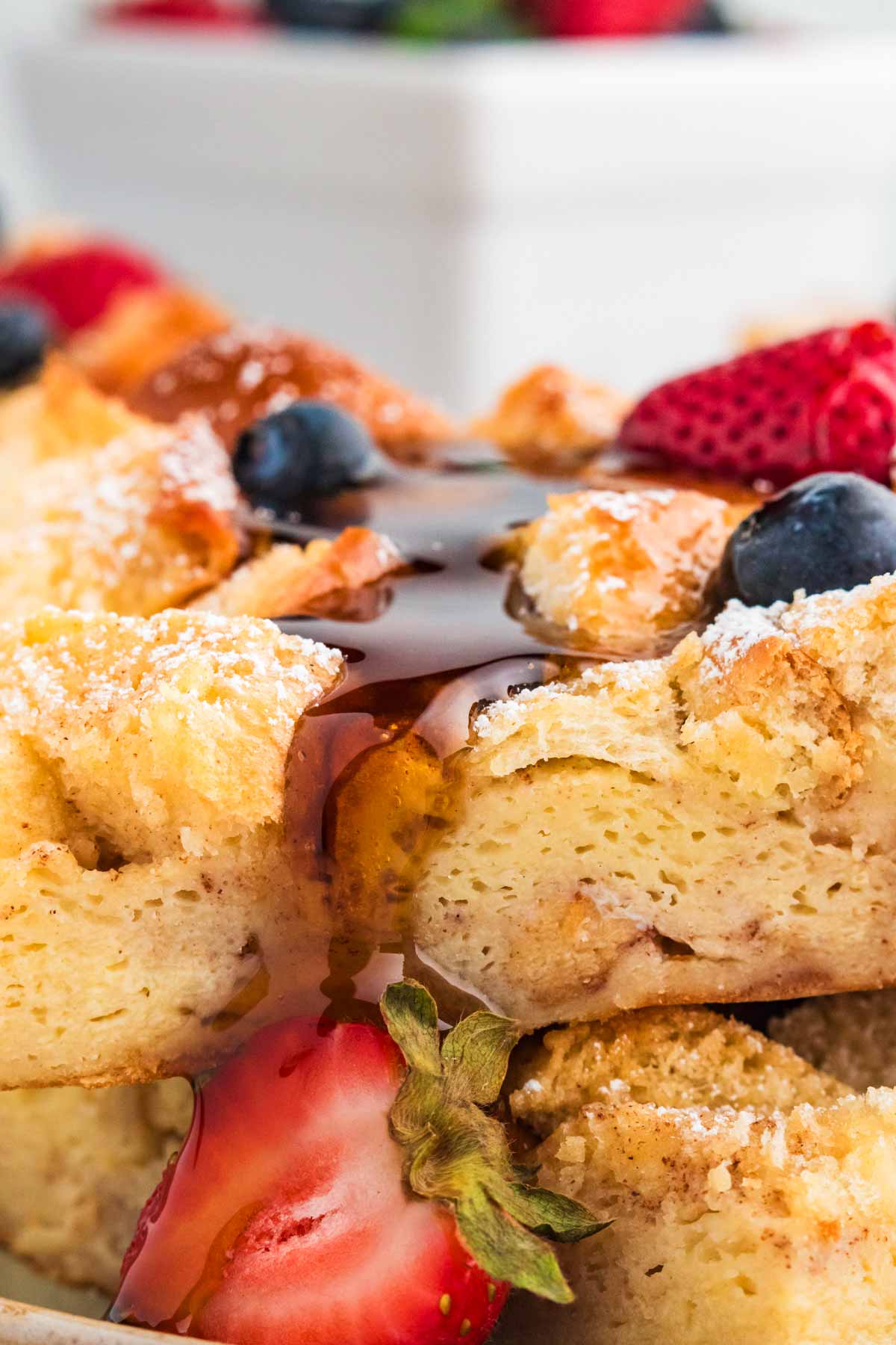 close up photo of brioche French toast casserole slices with maple syrup
