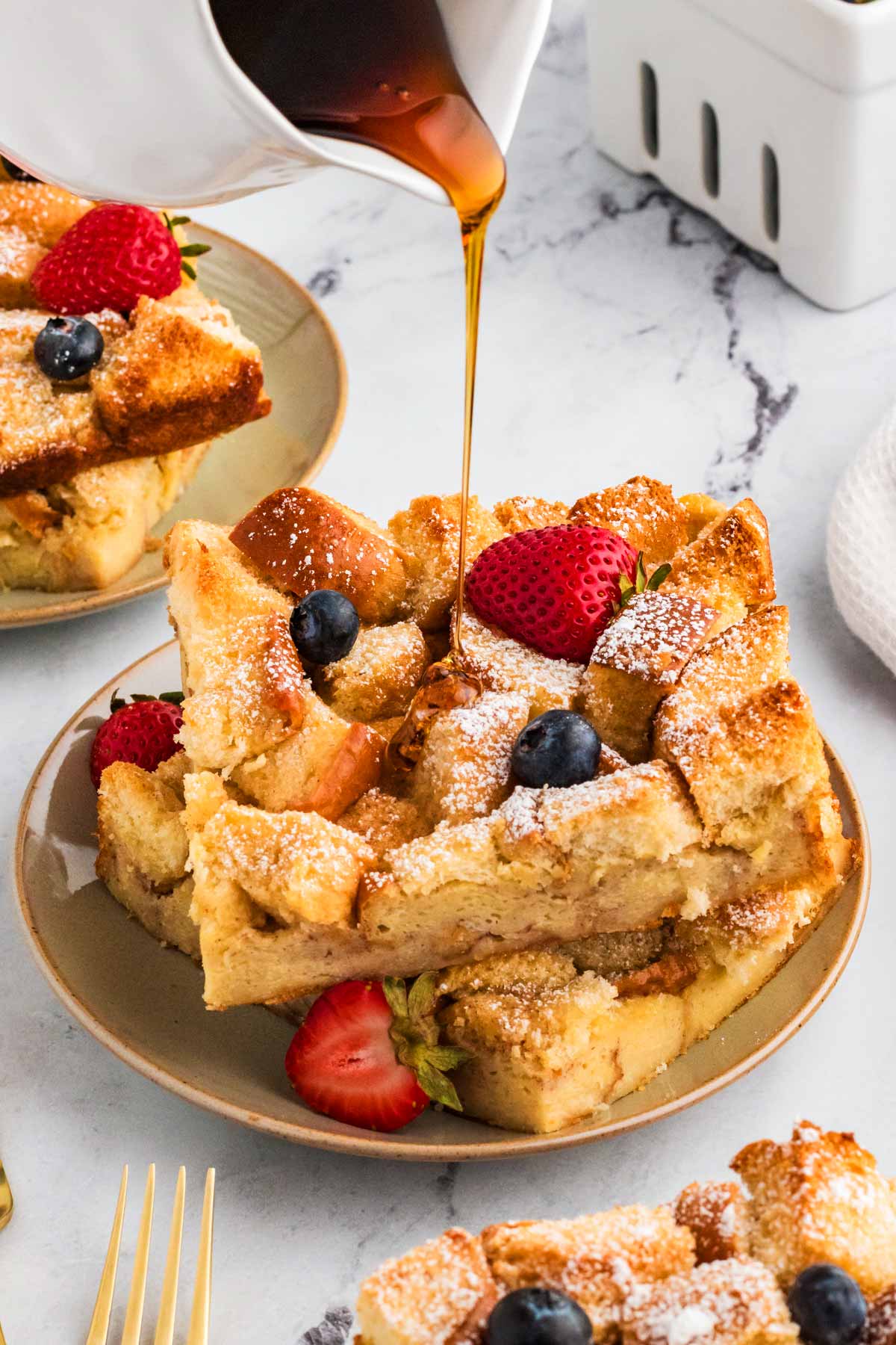 maple syrup drizzling over slices of brioche French toast casserole