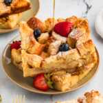 maple syrup drizzling over slices of brioche French toast casserole