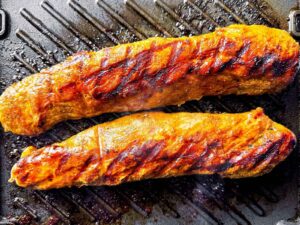 overhead view of cooked pork tenderloin on grill
