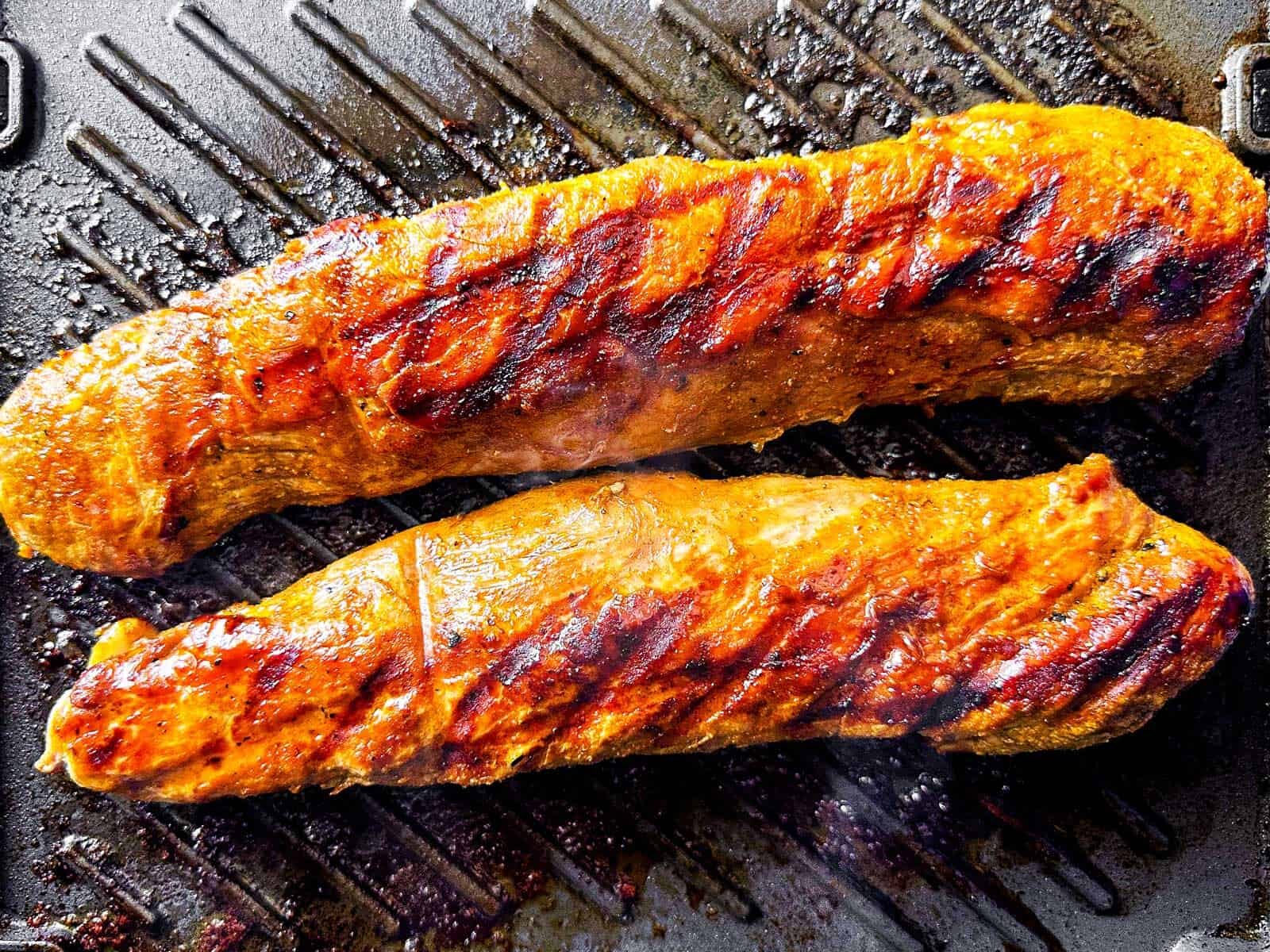 overhead view of cooked pork tenderloin on grill