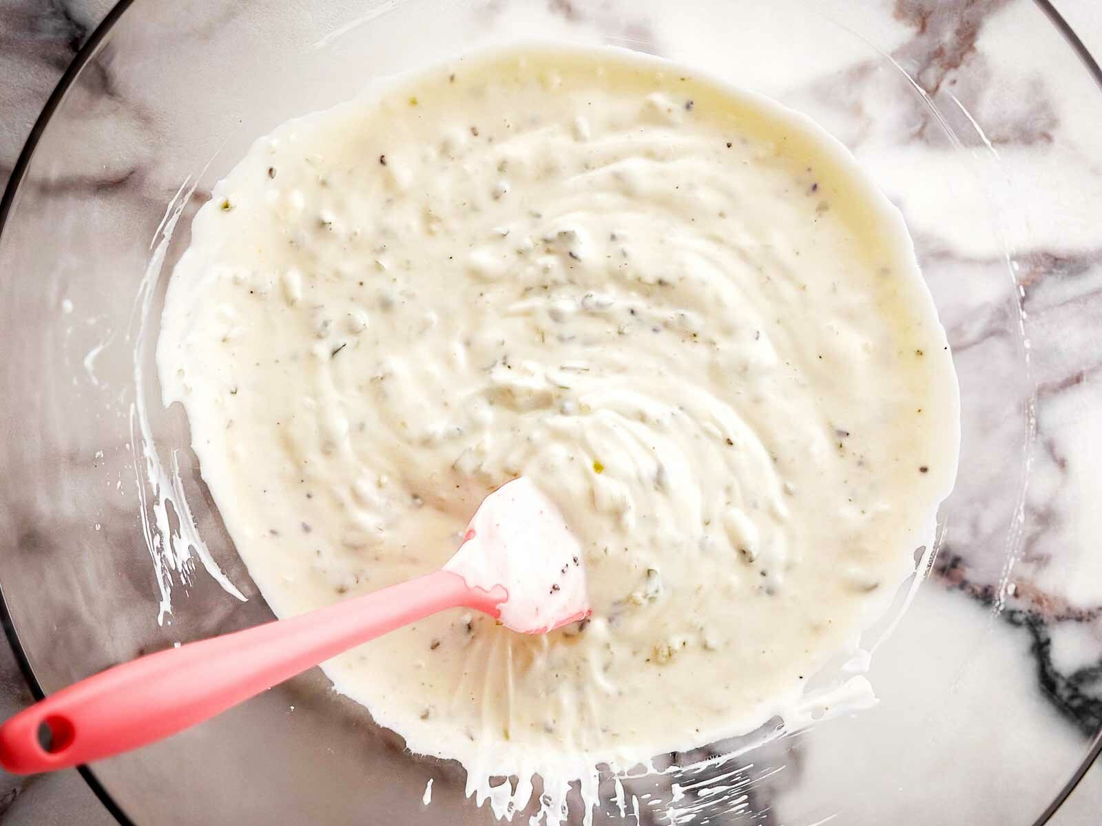 overhead view of mayonnaise dressing in clear glass bowl
