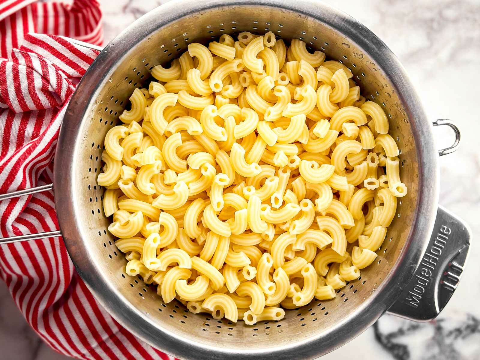overhead view of boiled macaroni draining in colander