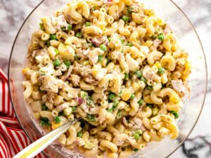overhead view of mixed tuna macaroni salad in clear glass bowl