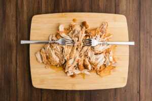 shredded chicken on wooden board