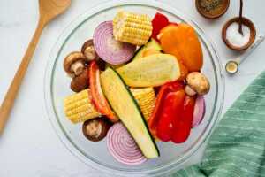 seasoned cut up vegetables in glass bowl