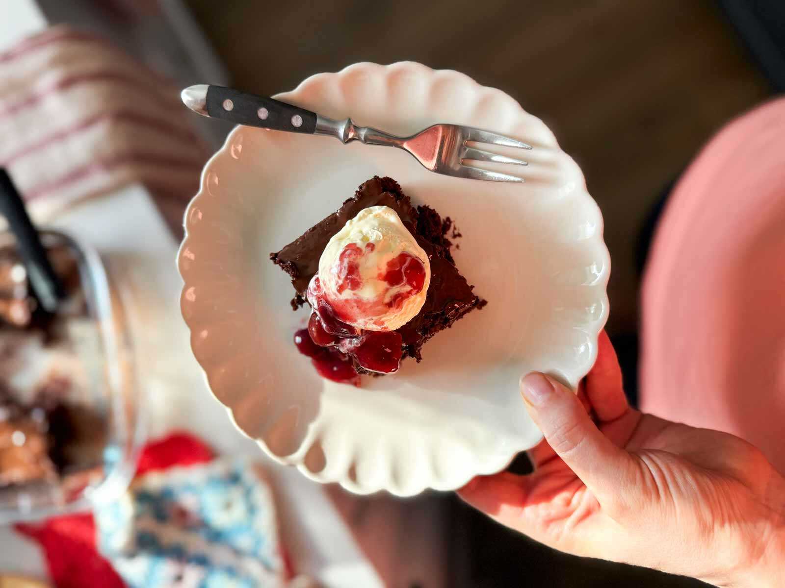holding a plate with a Black Forest brownie sundae